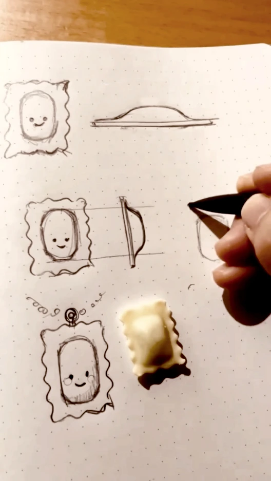 Les premiers croquis du pendentif Raviole Coquette dans un carnet