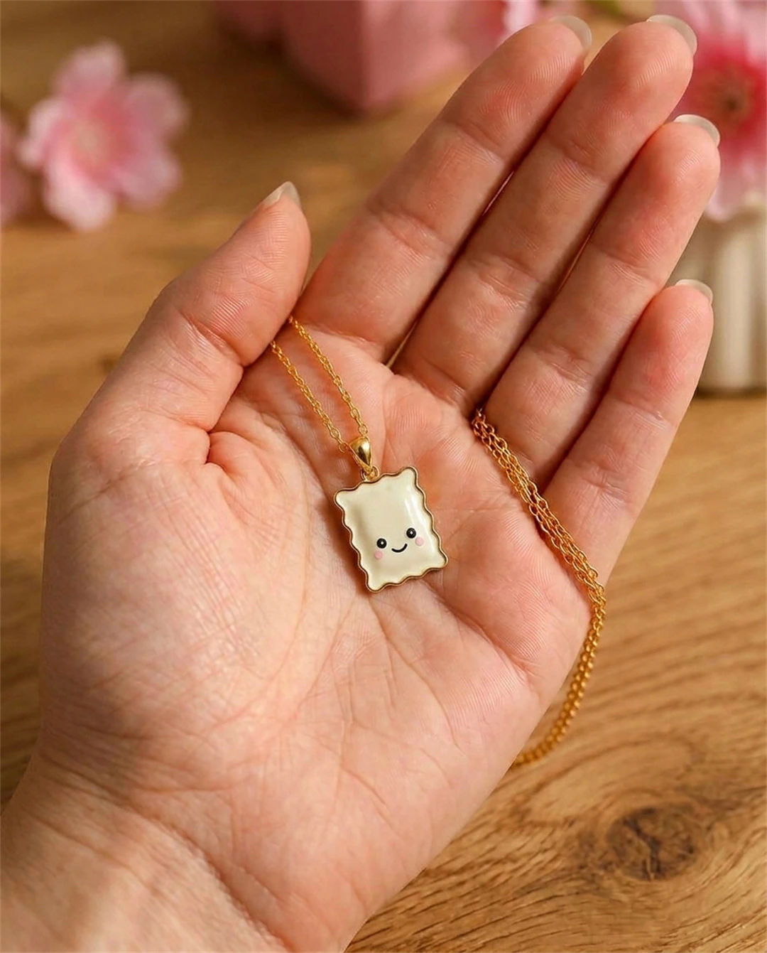 Le véritable collier Raviole Coquette dans une main